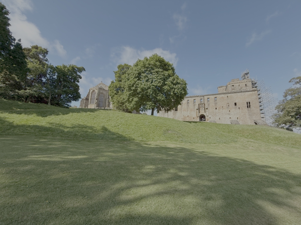Parish and castle, with trees and lawn in the foreground.